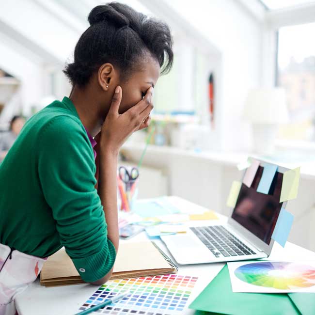 A graphic designer at her desk having a creative block
