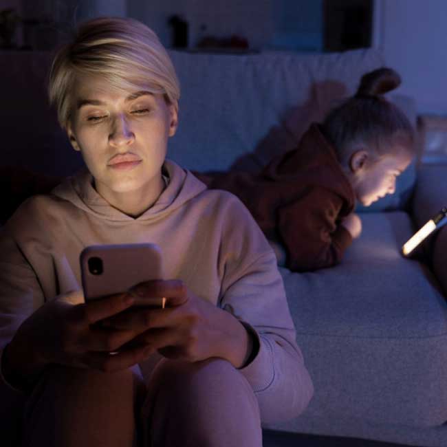 A mother and a daughter using their cellphones