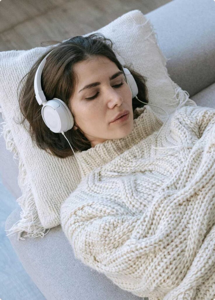 a woman with headphones listening to a hypnosis recording